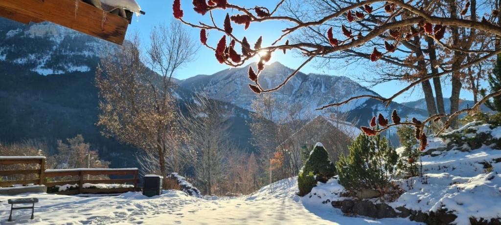 Ein schneebedeckter Weg mit einer Bank und Bergen im Hintergrund in der Unterkunft Chambres D'hôtes Le Montagn'Art in Beauvezer