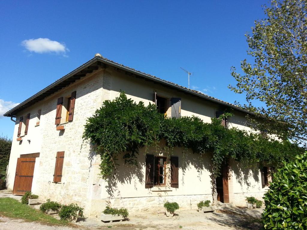 a white house with ivy on the side of it at Gîte de Viole in Monclar-de-Quercy