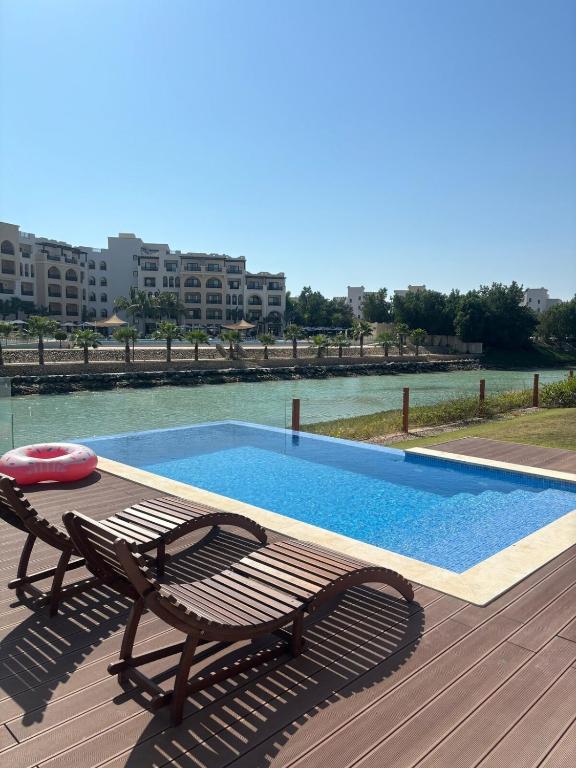 a swimming pool with a bench and a table and a swimming pool at Hawana Salalah Resort - FV 5 in Salalah