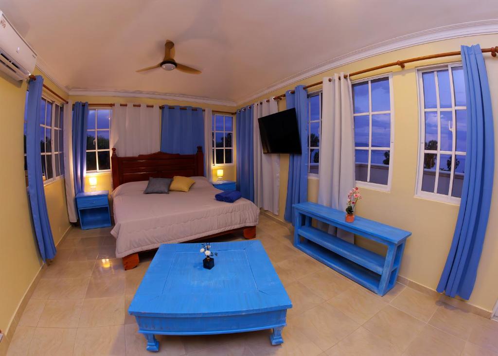 una camera da letto con un letto con mobili e finestre blu di Hotel la Saladilla Beach Club a Santa Cruz de Barahona