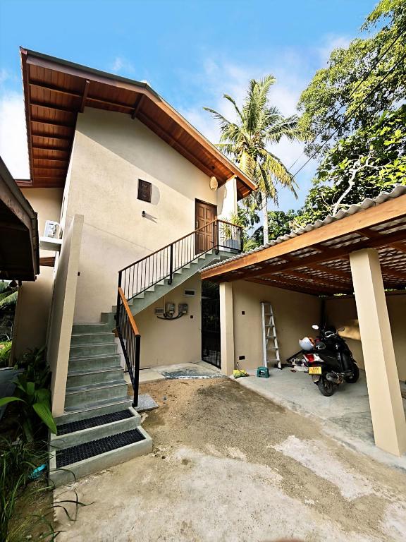a house with a staircase in front of it at Asoka's Place in Unawatuna