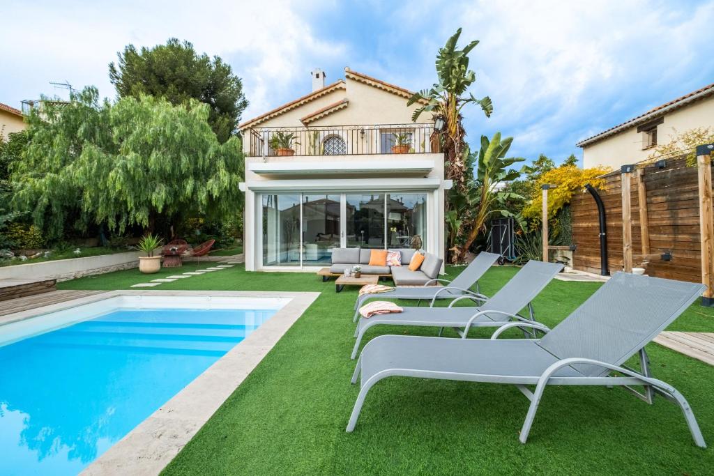 ein Haus mit Pool und Rasenflächen in der Unterkunft Villa 8 personnes bord de mer in Cros-de-Cagnes
