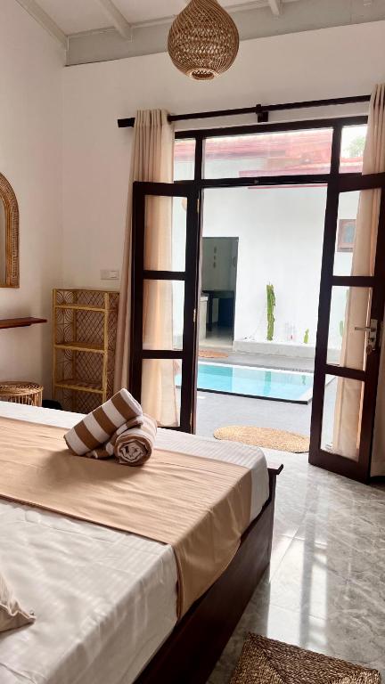 a bedroom with a large bed and a large window at Casa Sinabowewa in Ahangama