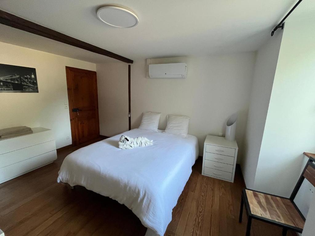 eine Katze, die auf einem weißen Bett in einem Zimmer liegt in der Unterkunft Domaine Cherps Spa - Zen in Vielleségure