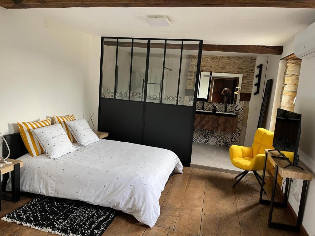 une chambre avec un lit et une chaise jaune dans l'établissement Domaine Cherps Spa - Sérénité, à Vielleségure