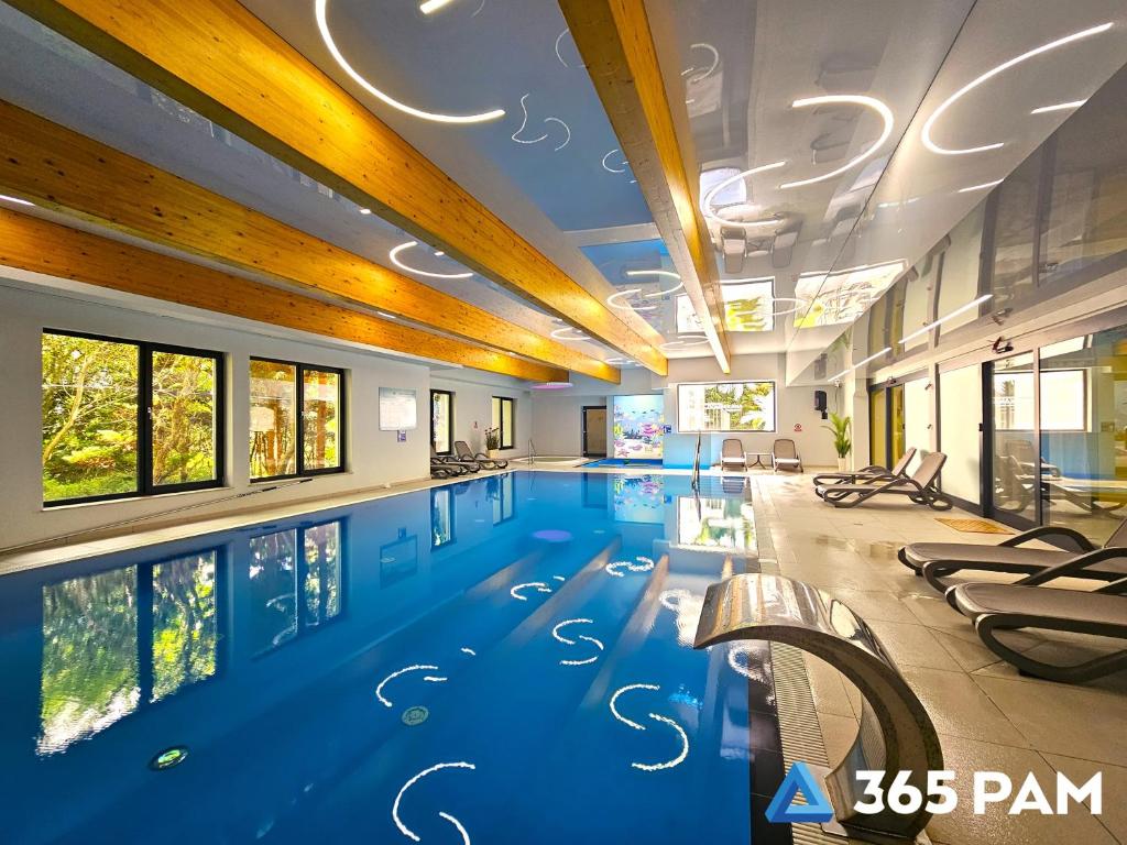 a large swimming pool in a building with a swimming pool at 365PAM - Studio C35 Dominikana in Sianozety