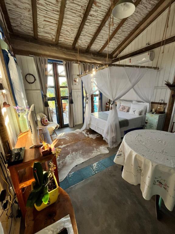 une chambre avec un lit et une table dedans dans l'établissement Chalé Perto Do Céu, à São Thomé das Letras