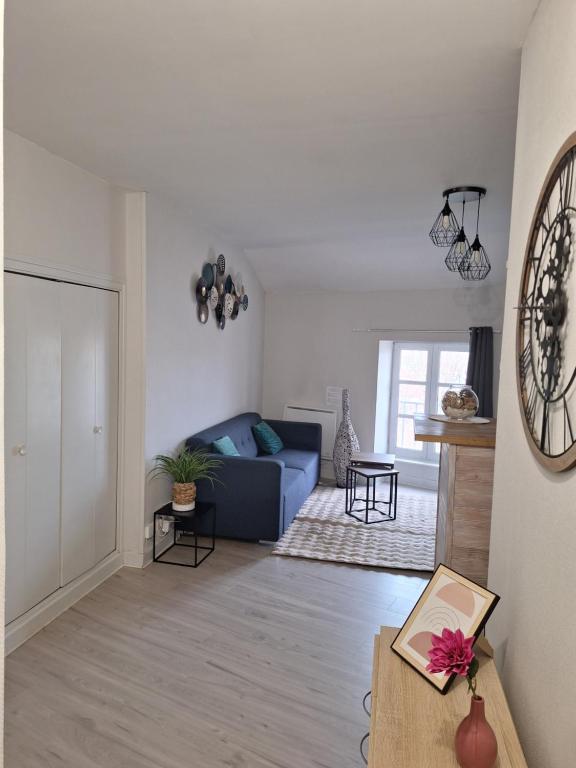 un salon avec un canapé bleu et une table dans l'établissement Charmant F2 centre Issoire avec jolie Vue Sancy et Livradois- WiFi, à Issoire