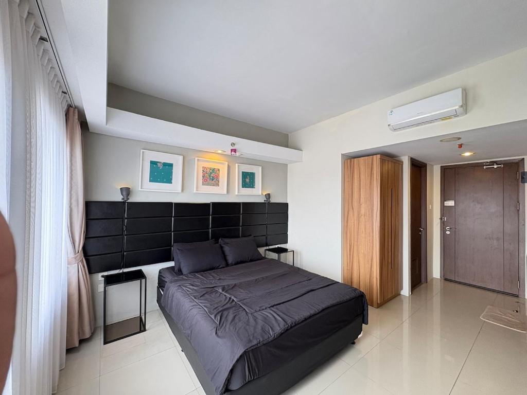 a bedroom with a large bed in a room at Cozy Bogor Icon Studio Apt bogor W Pool in Kedunghalang