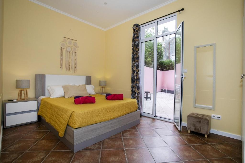 a bedroom with a bed and a sliding glass door at Furnas Cozy Inn in Furnas