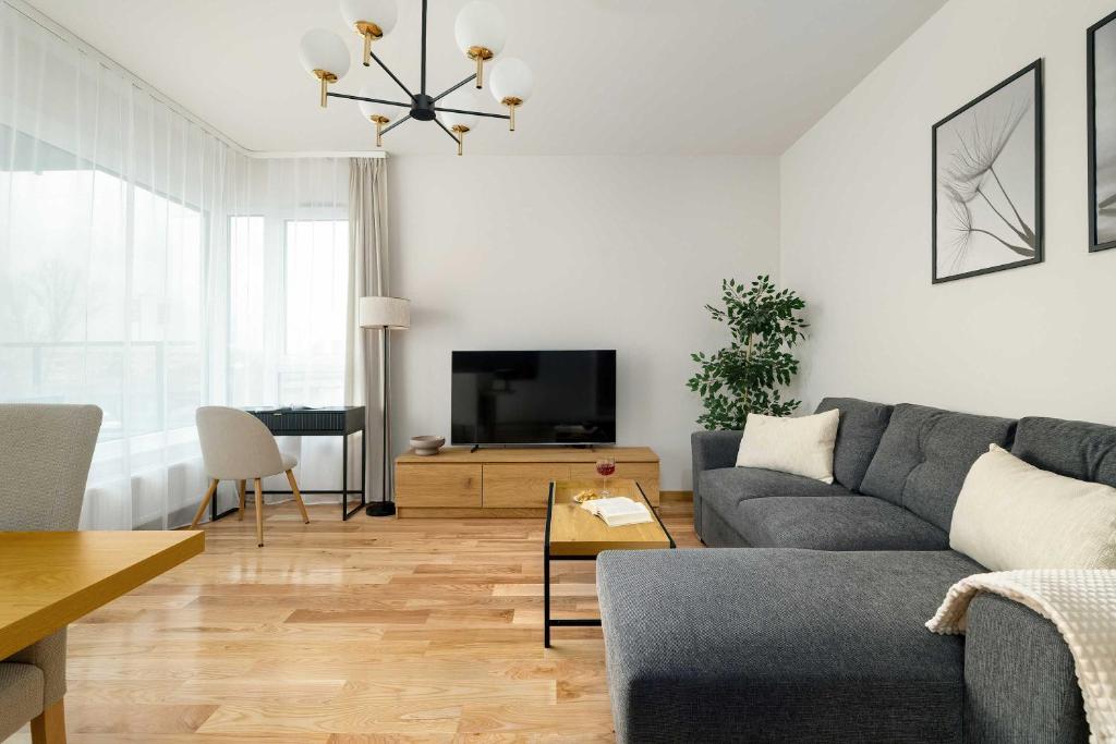 a living room with a couch and a tv at Luxury Apartment with Parking & Terrace Remote Work by Renters Prestige in Poznań