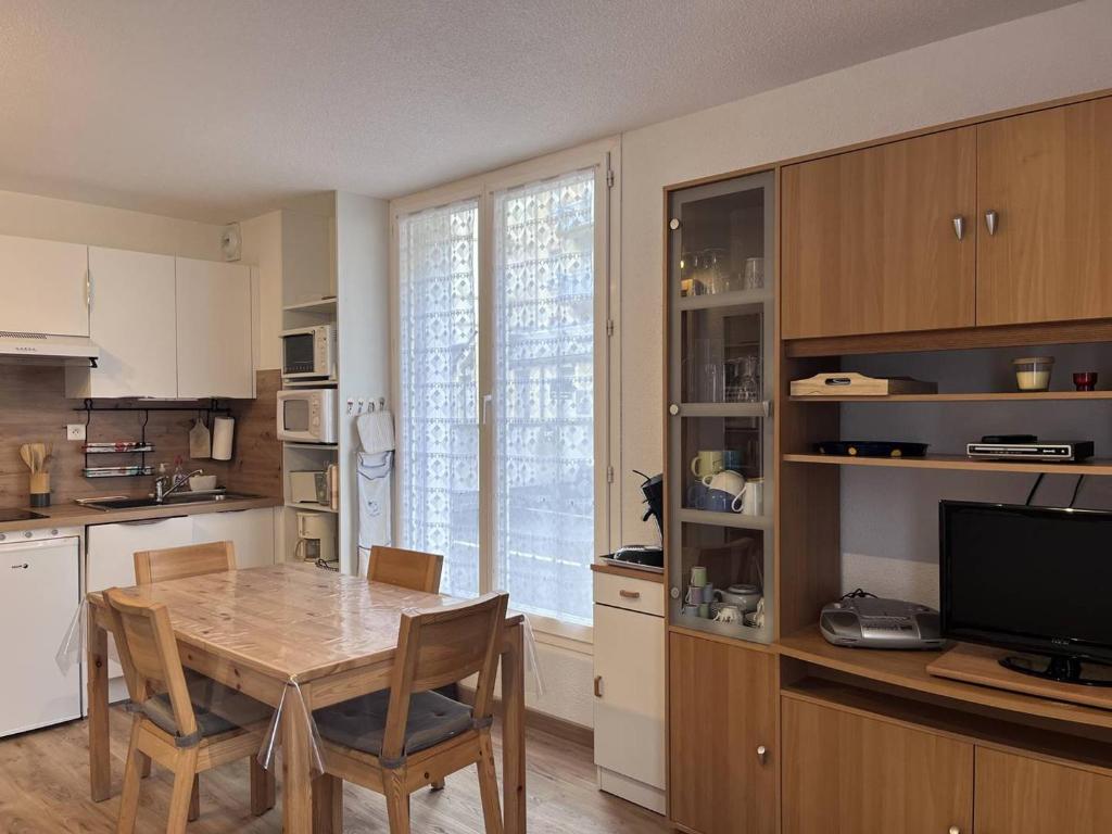 une cuisine avec une table de salle à manger et une télévision dans l'établissement Appartement Central avec Parking à Cauterets - FR-1-812-1, à Cauterets