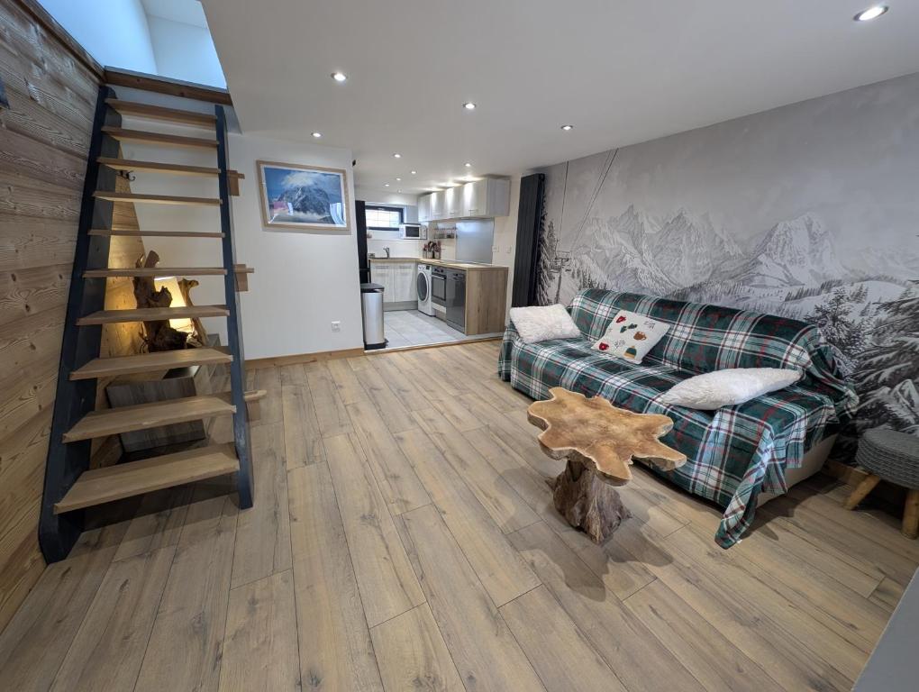 een woonkamer met een bank en een houten vloer bij Maisonnette cosy montagne in La Garde