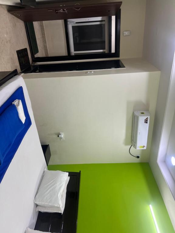 a small room with a microwave and a green floor at HOTEl BOMMANA RESIDENCY in Godāvari