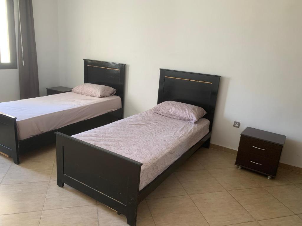 two beds are in a room withermottermott at Appart bacha in Kenitra