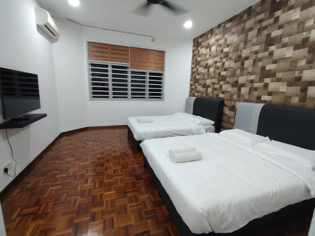 关丹YNY Guest House的一间卧室，配有两张床和一台平板电视