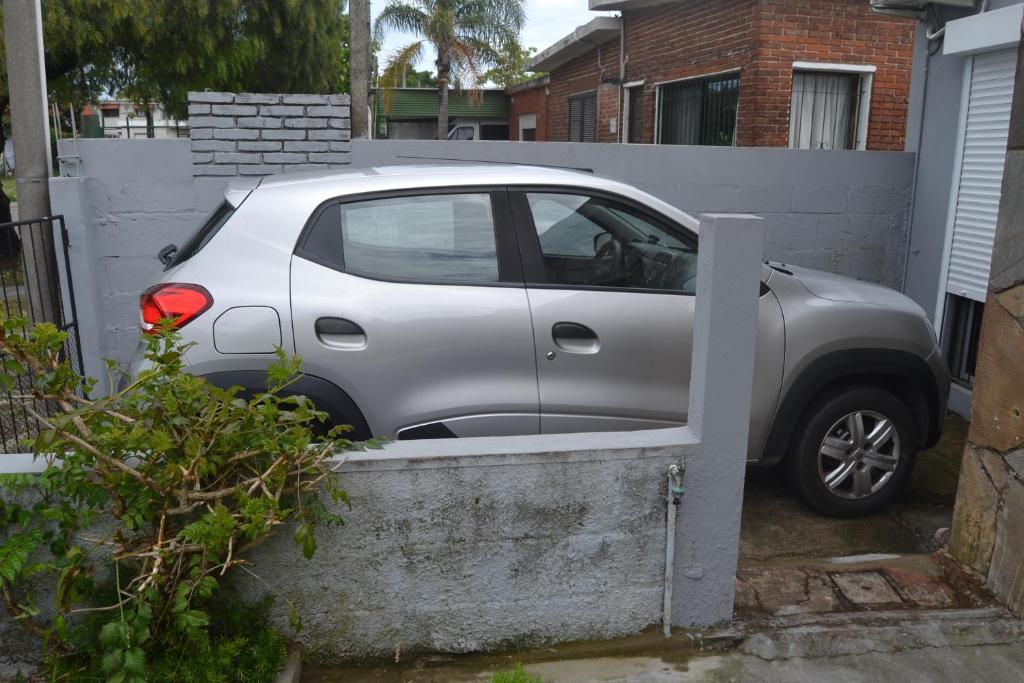 Ein kleiner silberner Wagen parkte neben einem Zaun. in der Unterkunft Habitación con Baño Privado in Maldonado