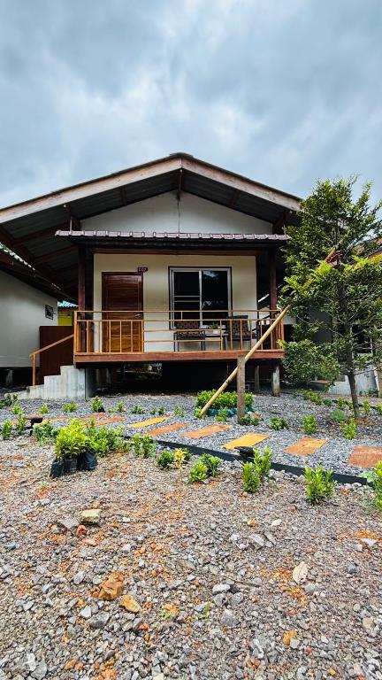a house with a porch and a balcony at Cha homestay in Phanom