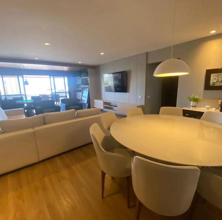 a living room with a couch and a table and chairs at Carnatal Agora- 30m da Arena das Dunnas in Natal