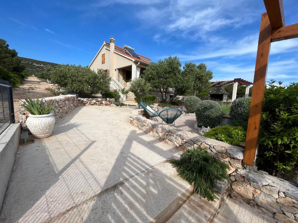 a walkway with a bench in front of a house at Modernes Ferienhaus Robinson In Dobropoljana in Dobropoljana