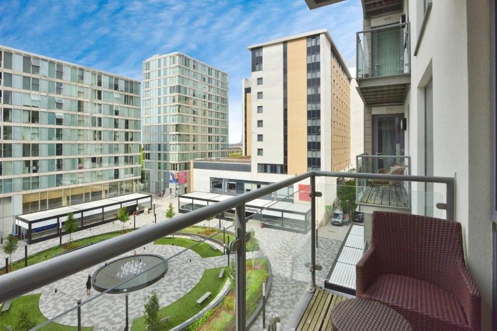ein Balkon mit Stuhl und Tischen und Gebäuden in der Unterkunft Executive apartment in central Milton Keynes in Milton Keynes