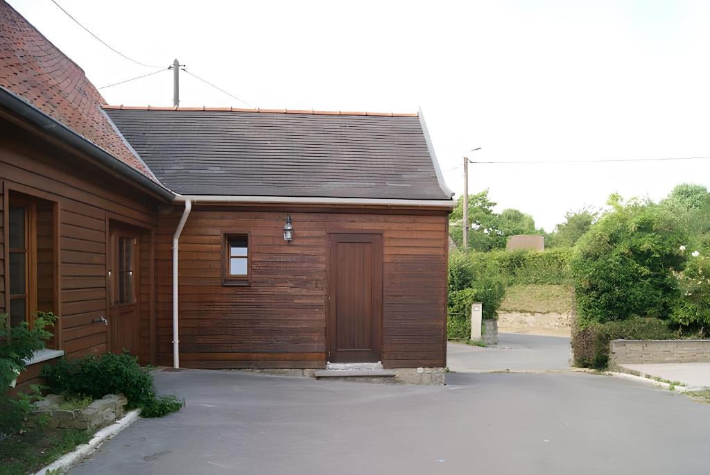 eine Holzgarage mit einer Tür und einer Einfahrt in der Unterkunft Gite 5 Pers proche Wimereux in Belle-et-Houllefort