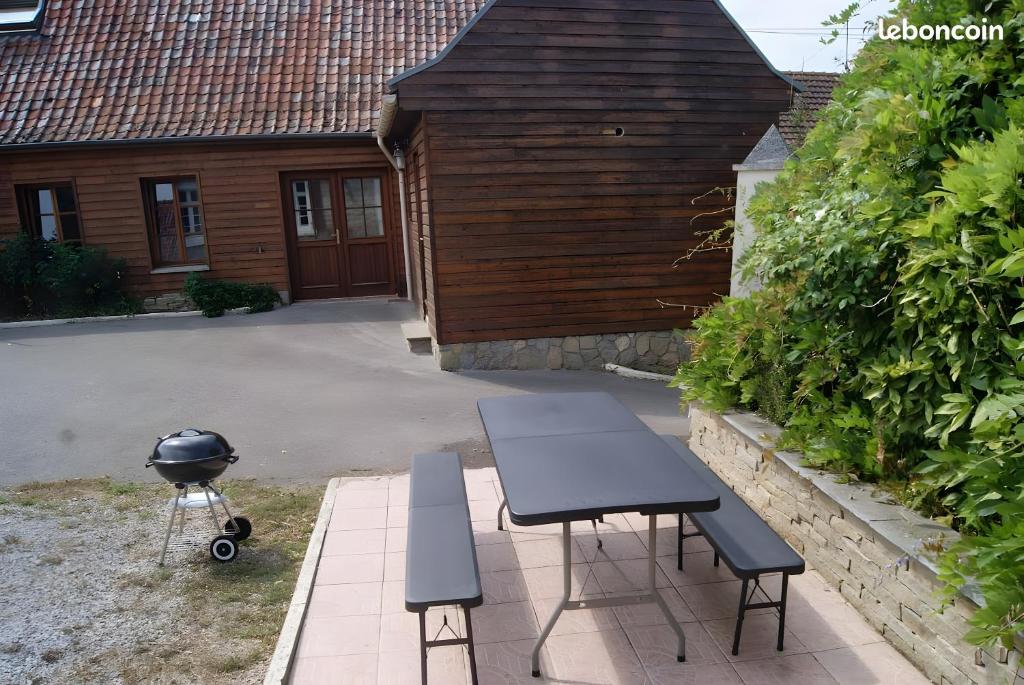 Una mesa de picnic y una parrilla frente a una casa. en Gite 5 Pers proche Wimereux, en Belle-et-Houllefort