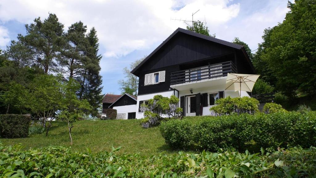 ein schwarzes und weißes Haus auf einem Feld in der Unterkunft Ferienhaus in ruhiger Lage auf einem großen Grundstück, ideal für Naturliebhaber und Ruhesuchende in Tuhelj