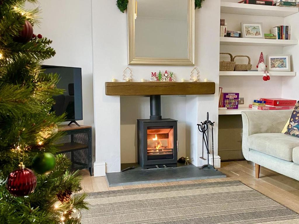 un salon avec une cheminée et un arbre de Noël dans l'établissement 9 Snowdrop Cottages, à Winterton-on-Sea