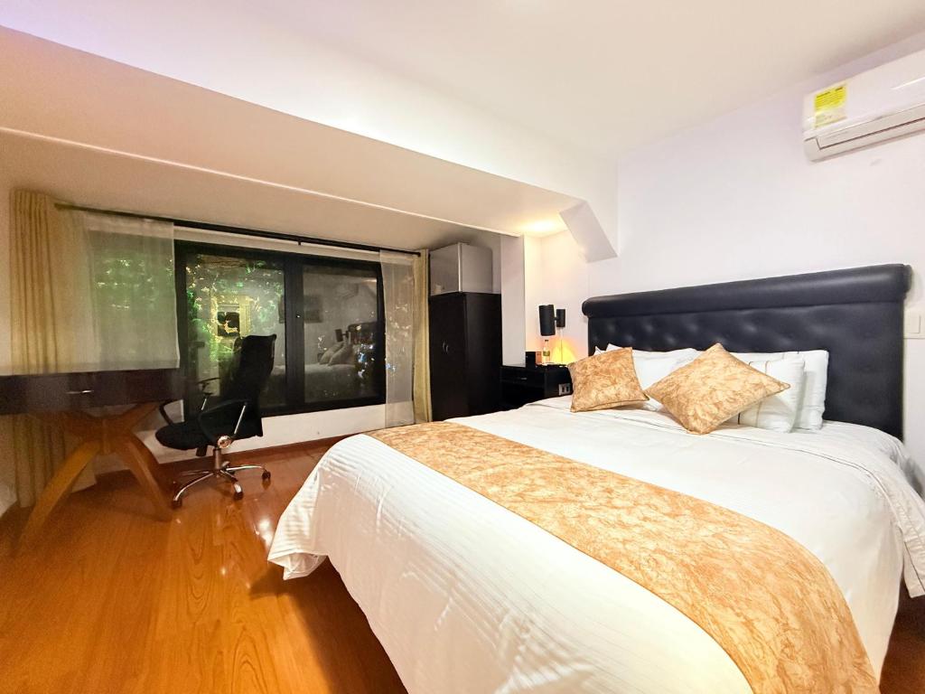a bedroom with a large bed with a large window at Hotel Veler in Medellín