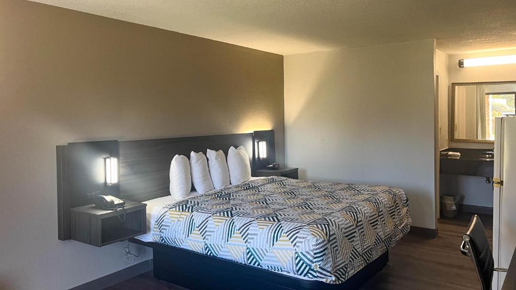 una habitación de hotel con una cama y un teléfono en Studio 6 - Stafford, VA - Quantico, en Stafford