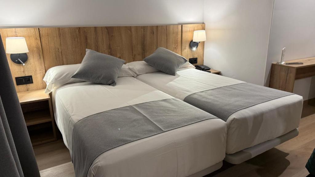 a bedroom with a large white bed with two pillows at Hotel Cervol by Nexta in Andorra la Vella