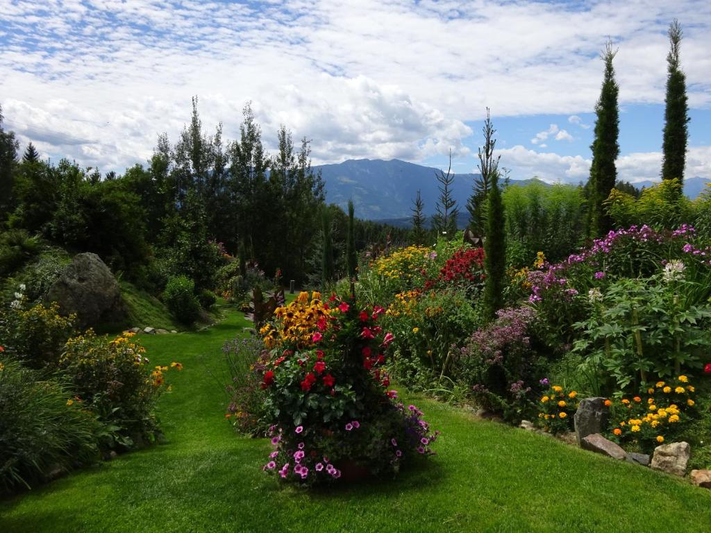 un jardin avec des fleurs colorées sur une pelouse verte dans l'établissement Ferienwohnung Anemoon In Millstatt, à Millstatt