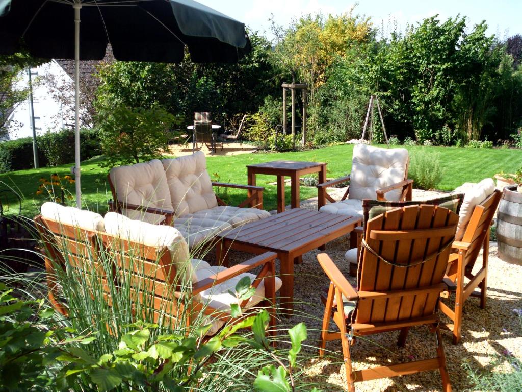 eine Terrasse mit einem Tisch, Stühlen und einem Sonnenschirm in der Unterkunft Ferienwohnung Familie Balko in Arnsberg