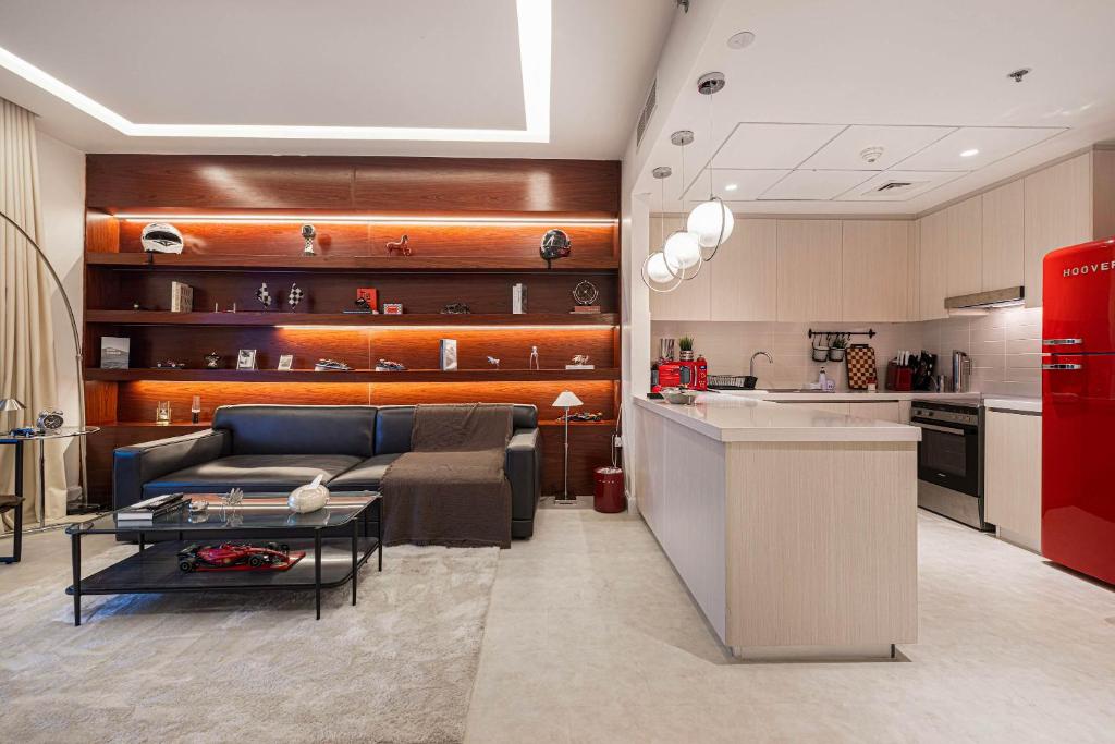 a living room with a couch and a kitchen at The F1 Scene Designer Apartment With120 Inch in Yas Island