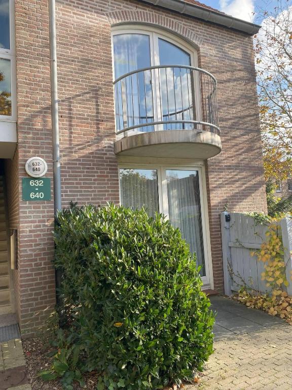a brick house with a balcony on top of it at "Tossens Ahoi" in Tossenserdeich
