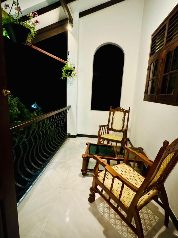 two chairs sitting on the balcony of a house at Villa Happy Nest in Unawatuna