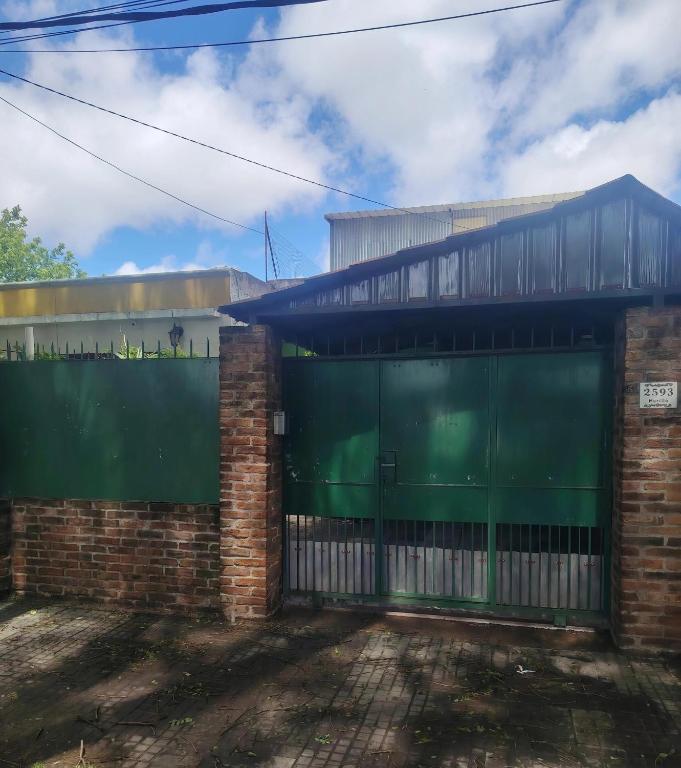 an old brick building with a green garage door at Murillo in Montevideo