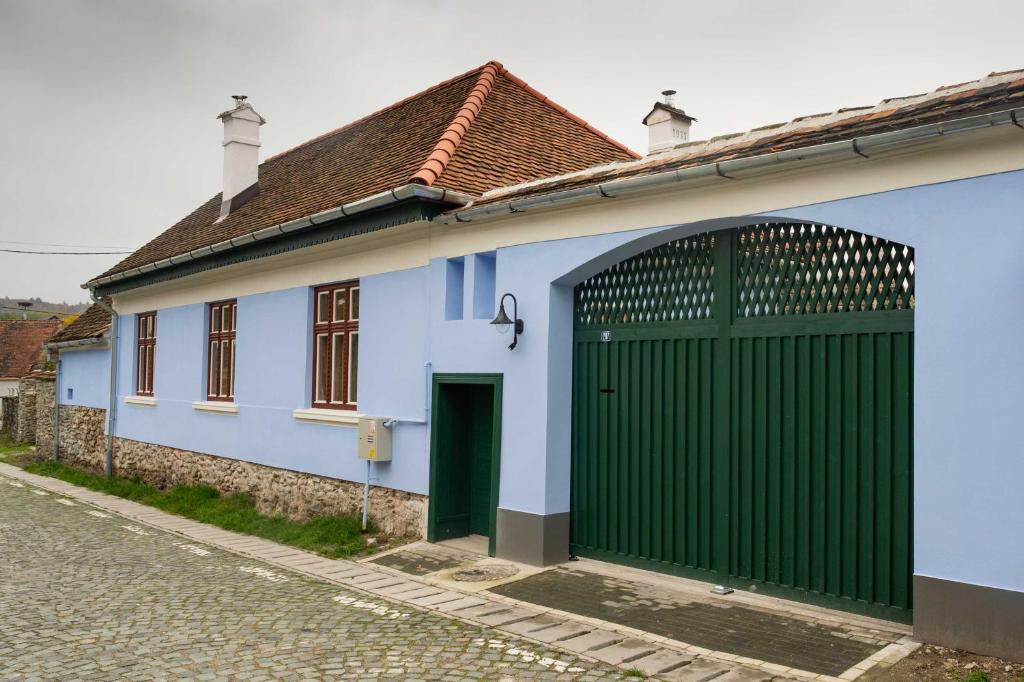 une maison bleue et blanche avec une porte verte dans l'établissement Curte la Munte - charming village house, à Sebeşu de Sus
