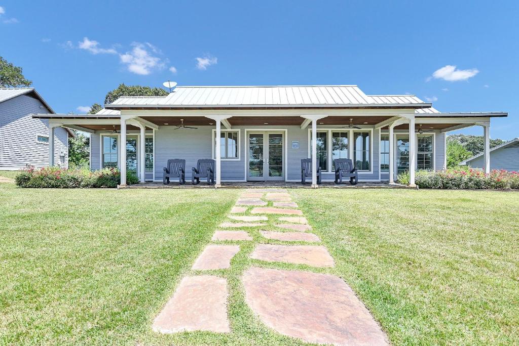 阿森斯Pine Cone Ranch - Cowboy Cottage的庭院内有石头路径的白色房子