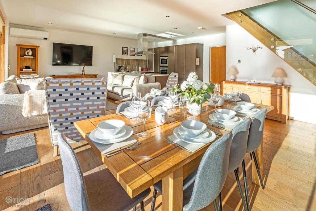 a dining room and living room with a table and chairs at Waters Edge 16, Heron Lodge in South Cerney