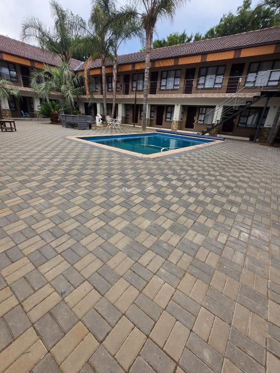 un patio con piscina frente a un edificio en Lakefield Hotel, en Benoni