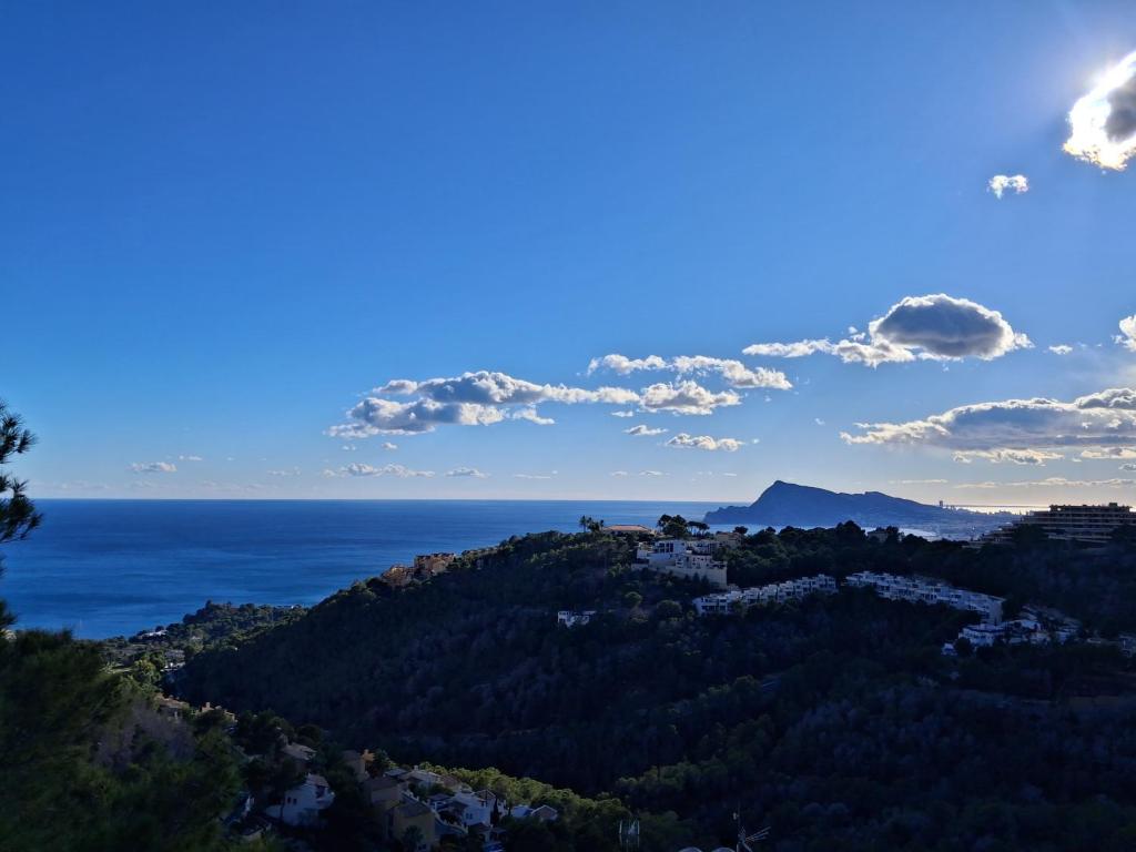 a view of the ocean and a town on a hill at Townhouse Altea Hills in Altea