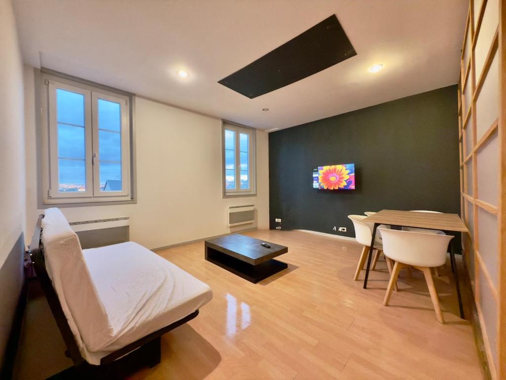 里摩日Appartement 4 spacieux Av Georges Dumas - DABNB的一间有床、桌子和电视的房间
