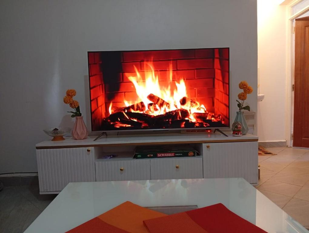 sala de estar con chimenea y hoguera en Cynergy 1b Apartment, Muthiga , Waiyaki Way, en Nairobi