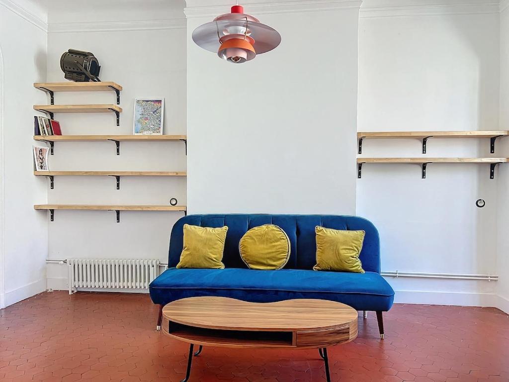 un canapé bleu avec des coussins jaunes dans un salon dans l'établissement Loft au coeur de Marseille - Spacieux & Unique, à La Celle-sous-Gouzon
