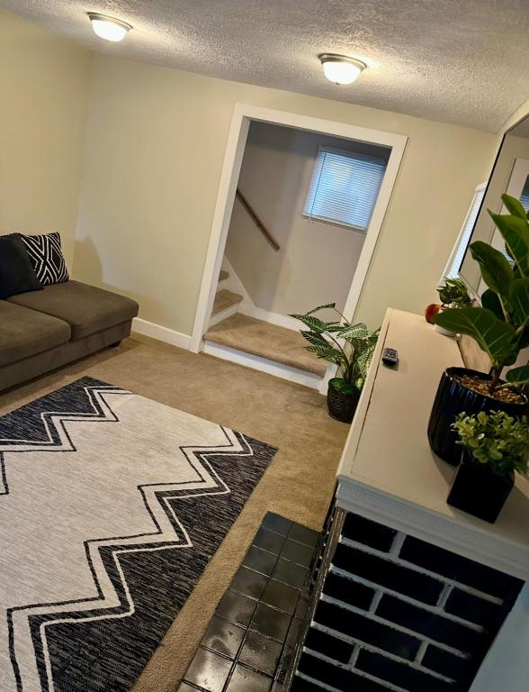 Una sala de estar con un sofá y algunas plantas. en Comfy 3 Bedroom entire home with cozy vibes, en Akron