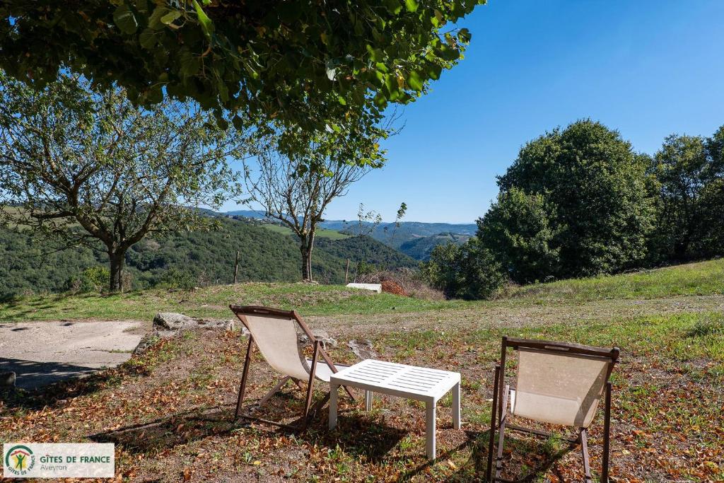 two chairs sitting next to a table and a table and chair at "Gîte de Bel Horizon" in Broquiès