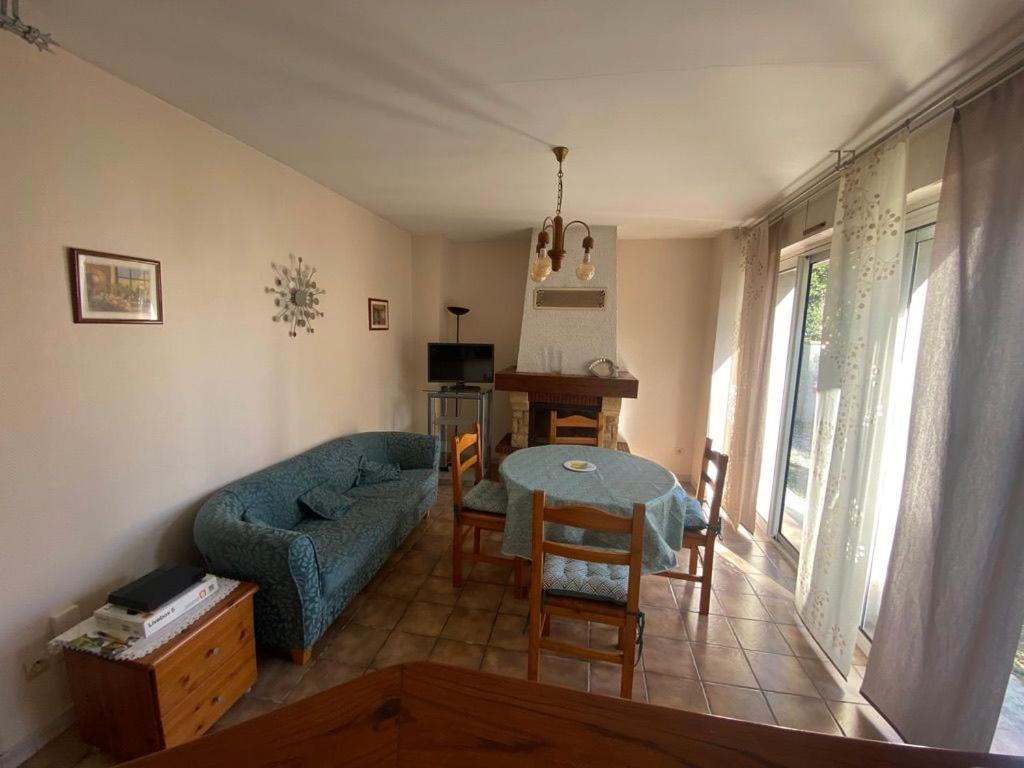 un salon avec un canapé bleu et une table dans l'établissement Les Buis, à Dieupentale