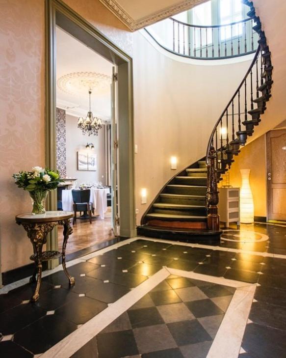 a hallway with a spiral staircase in a house at Parkhotel Gent Centrum in Ghent